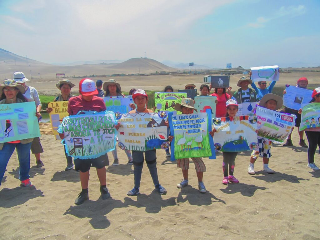 Niños y comunidad defienden el humedal Puerto Viejo con carteles sobre protección ambiental frente a presión inmobiliaria