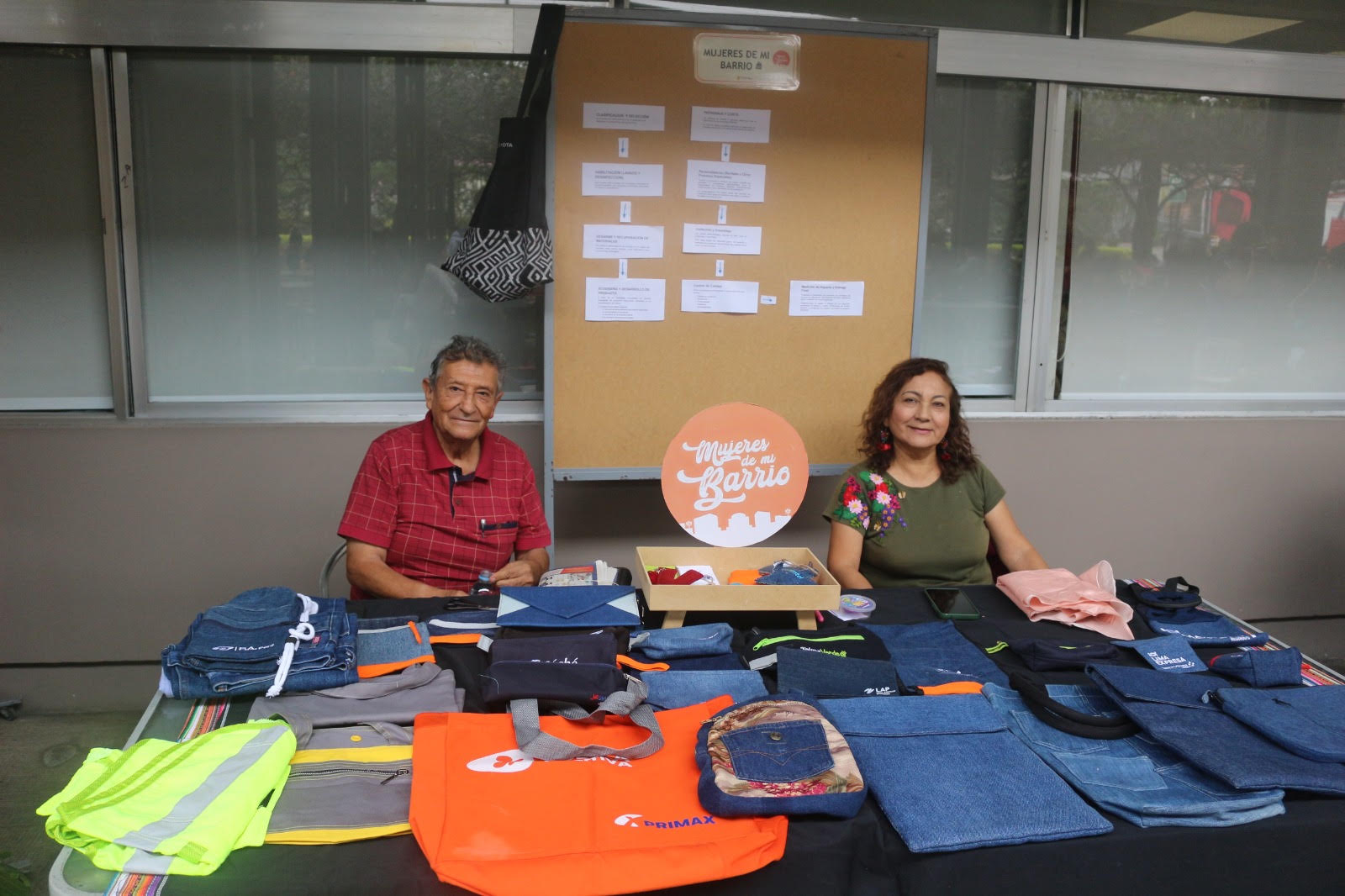 Mujeres de Mi Barrio mostrando productos textiles reciclados de Oportunidades Solidarias en Premios Verdes 2026