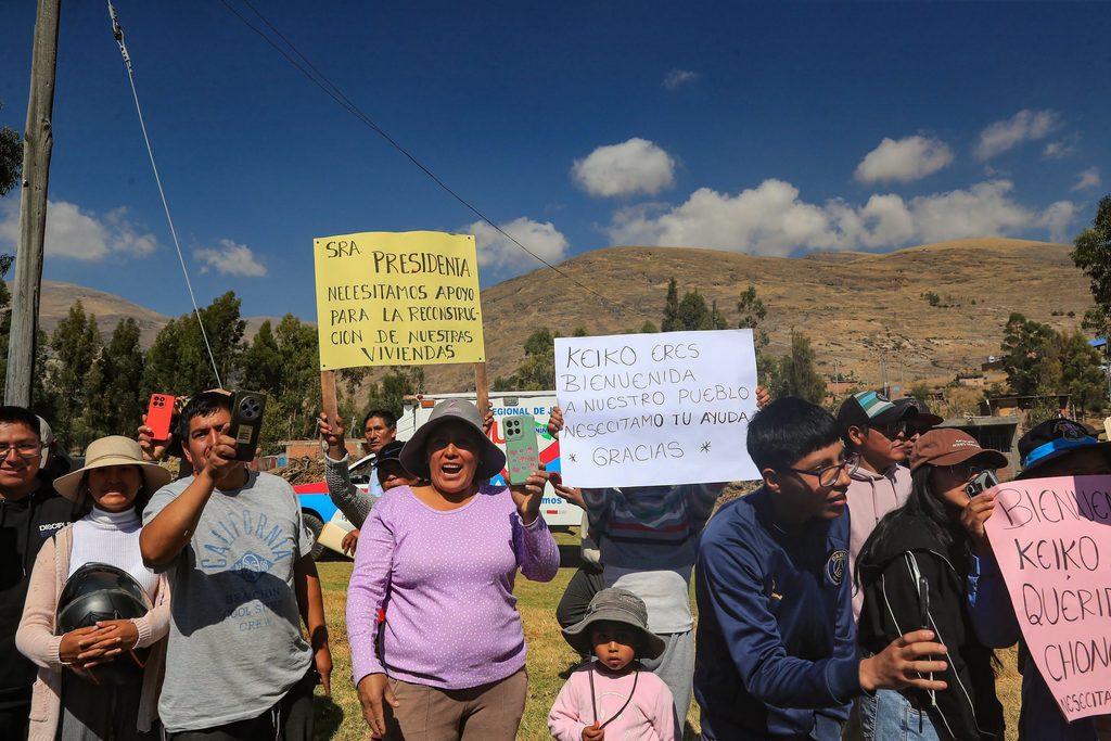 Pobladores de una zona rural del Perú muestran carteles durante una visita presidencial vinculada con la agenda social y la protección integral.