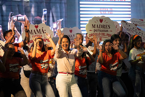 Lideresa política junto a simpatizantes durante un evento sobre la dimensión social y las condiciones de vida en el Perú.