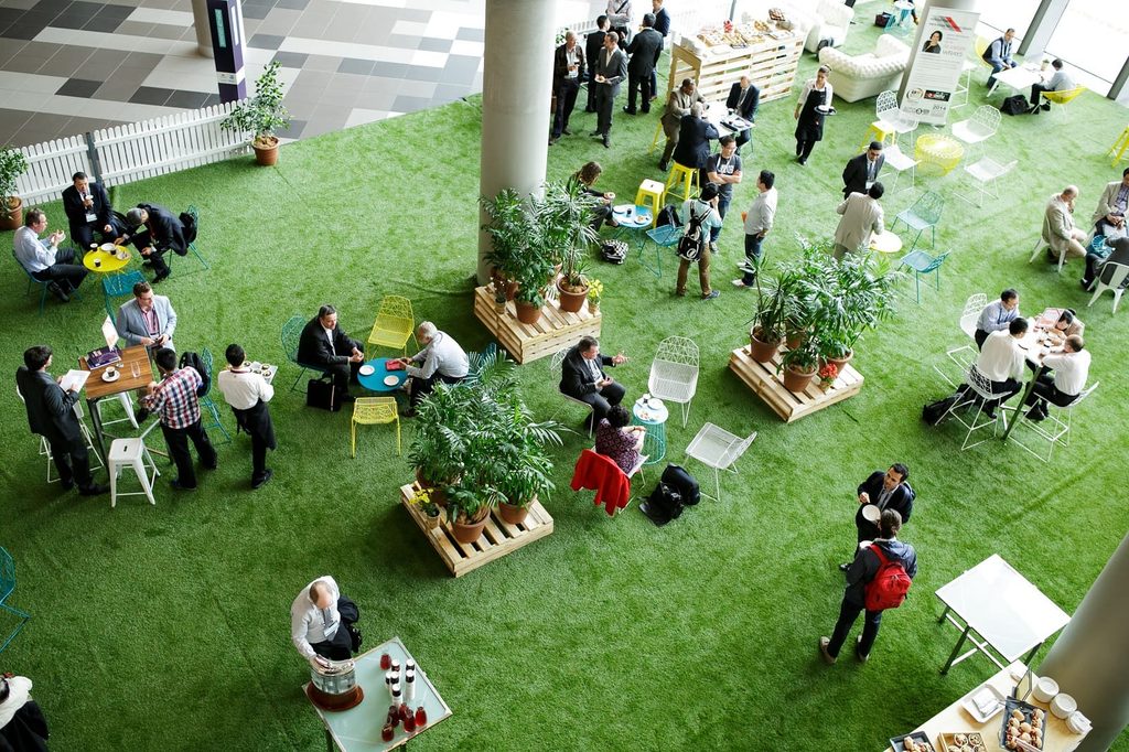 Ejecutivos participan en un evento de sostenibilidad empresarial y networking en un espacio corporativo.