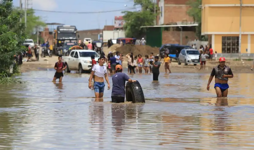 Personas cruzan una zona urbana inundada por el Fenómeno El Niño en el Perú.