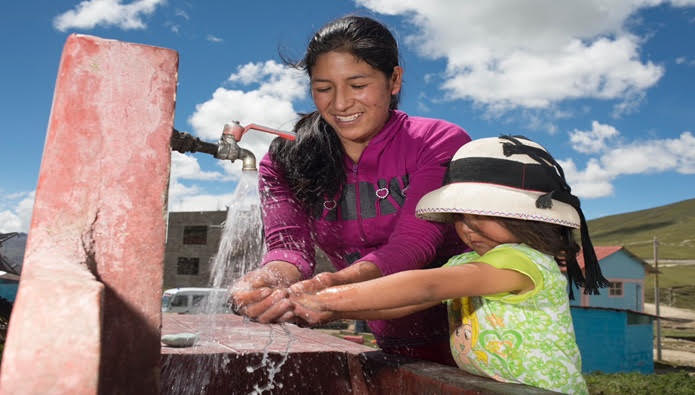 Mujer y niña usando agua potable en una comunidad rural del Perú.