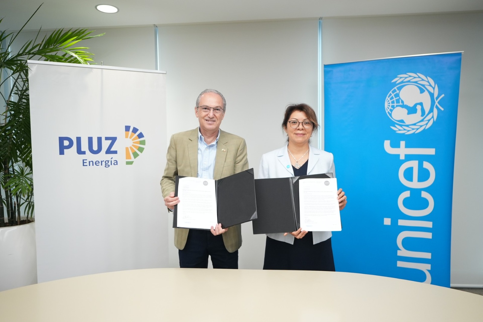 Pluz Energía y UNICEF durante la firma de un acuerdo de colaboración