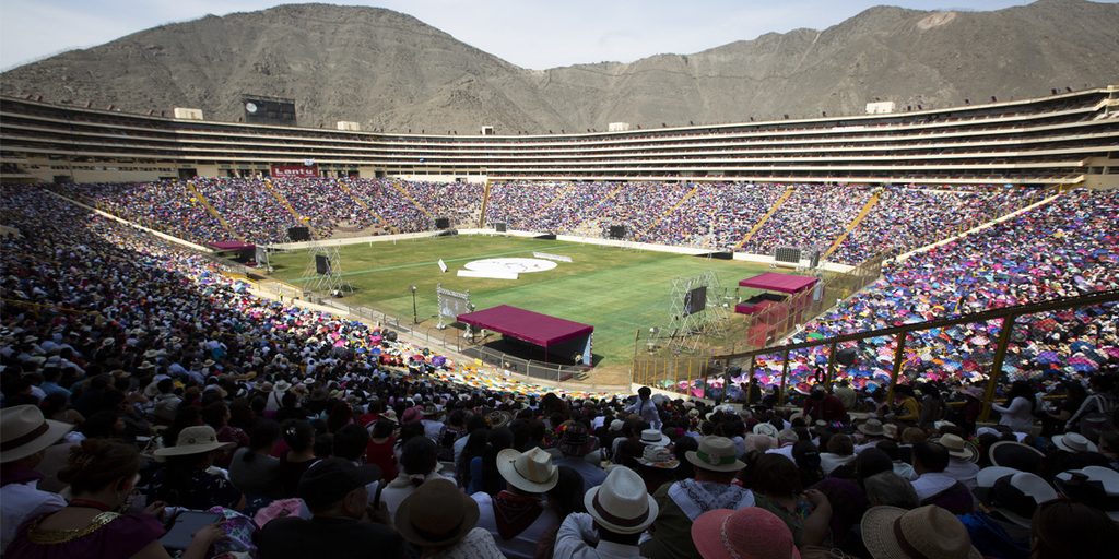Multitud reunida en el Estadio Monumental durante un encuentro religioso que refleja la diversidad religiosa en Perú.