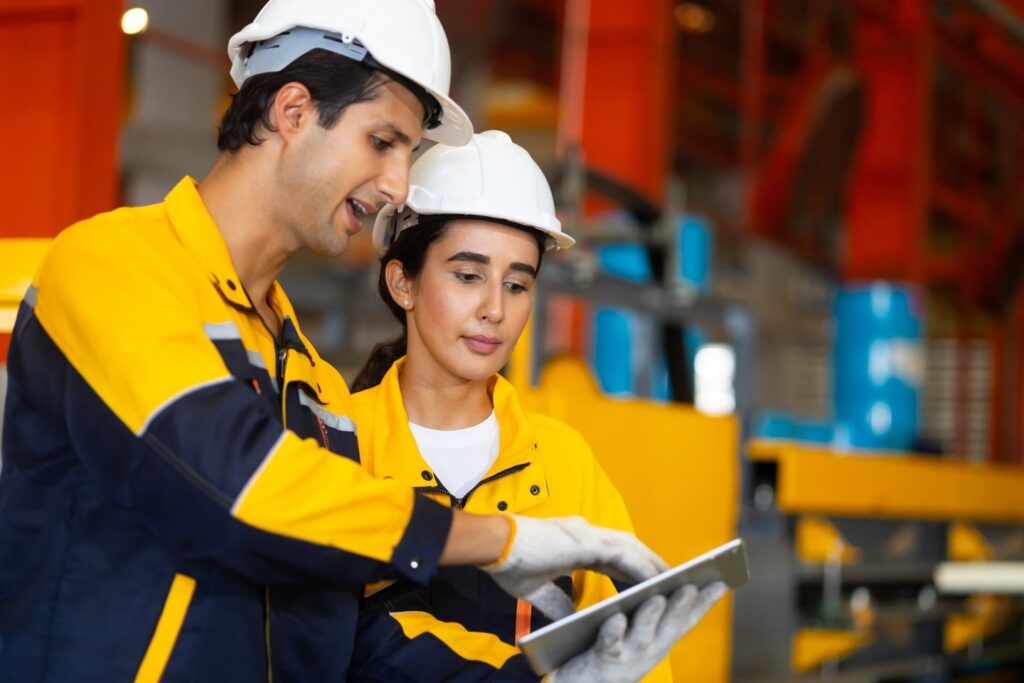 Trabajadores industriales revisan información en una planta, en el contexto de los sobrecostos laborales y el empleo formal en América Latina.