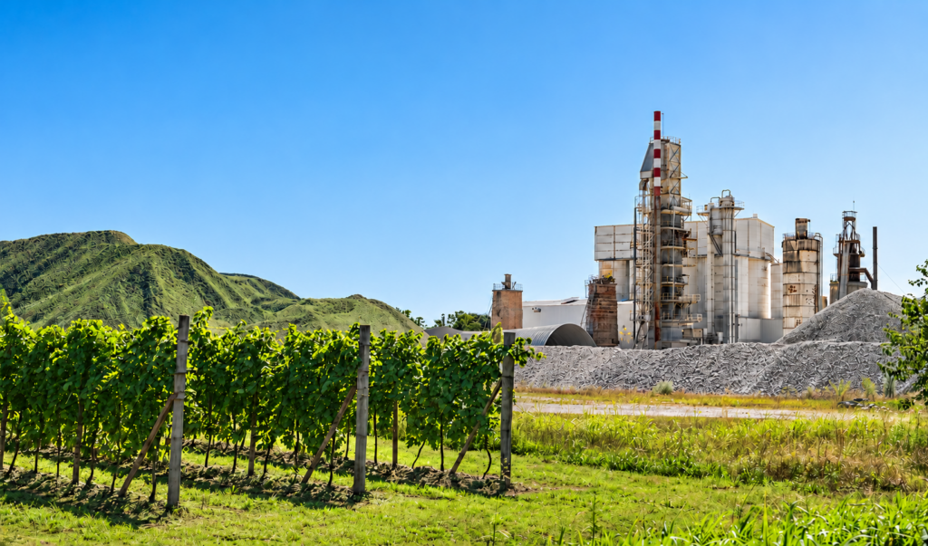 Planta cementera integrada a un entorno verde, vinculada a sostenibilidad, producción industrial y reducción del impacto ambiental.